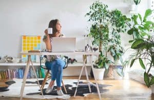 lady sitting at desk with cup in hand